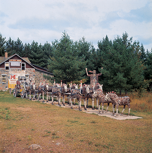 Fred Smith, Budweiser Display and (rear) Sacajawea, Wisconsin Concrete Park (site view, c. 1964–1965), Phillips, WI, 1948–64. Photo: Robert Amft, courtesy of Robert Amft Archive, Friends of Fred Smith, Inc.